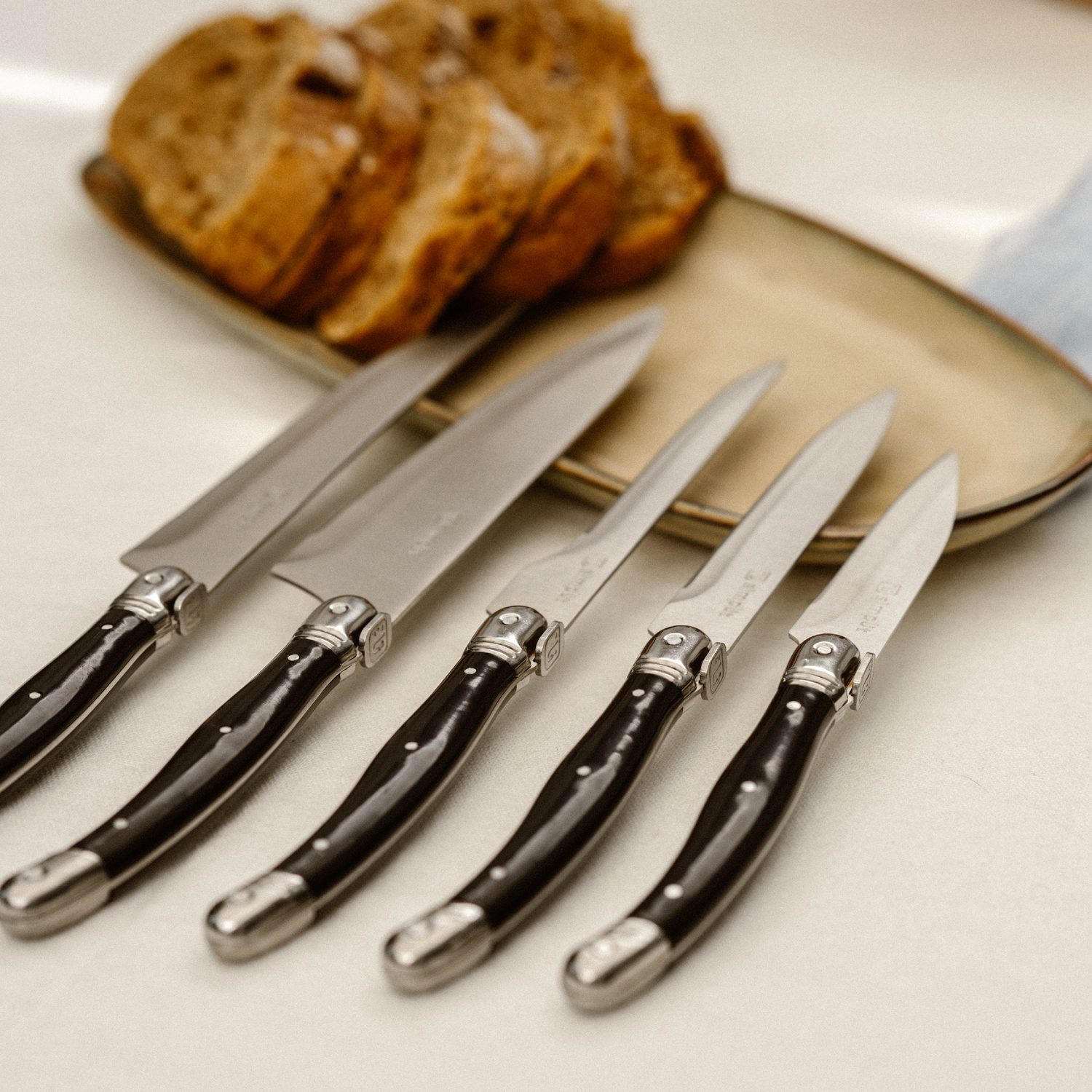 Simplit Set Cuchillos Paris 5 pcs — lay flat cuchillos acero inoxidable mango negro fondo crema