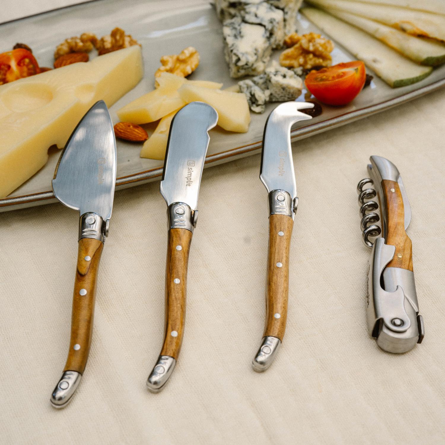 Simplit Set Cuchillos para Queso Provenza — lay flat set completo acero inoxidable y madera de olivo sobre fondo crema