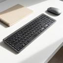 Teclado Inalámbrico Cygna Slim Grafito - a clean white desk with a mouse and notebook