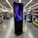 Pantalla Totem Publicitario 50" Touch  - in a retail store aisle, commercial lighting