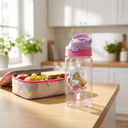 Botella Agua Niños Barbie & Pets 420ml - on a kitchen counter next to a lunchbox, bri