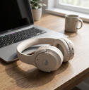 Audifonos Bluetooth Inalambricos Over  - on a wooden desk next to a laptop, soft dayl